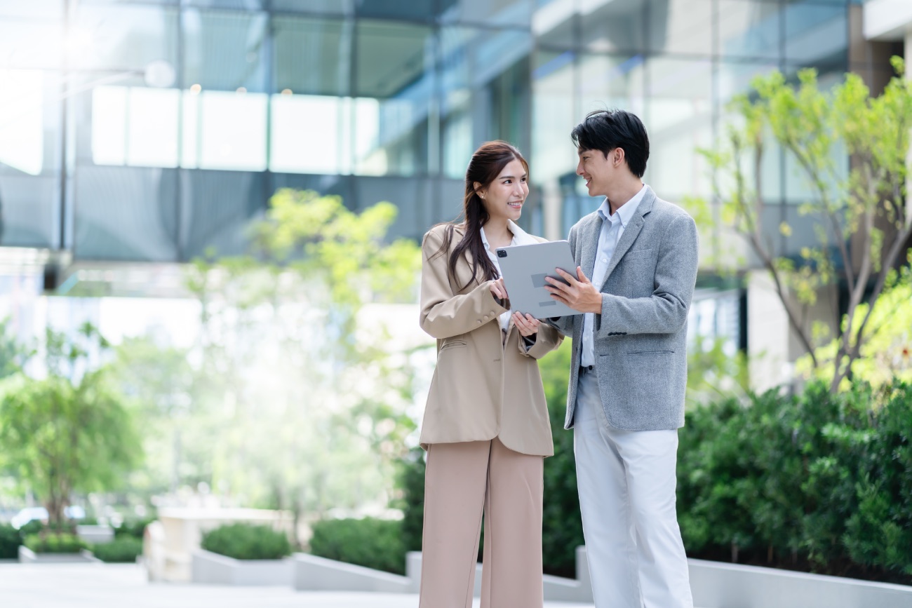 Twee professionals overleggen buiten met een tablet