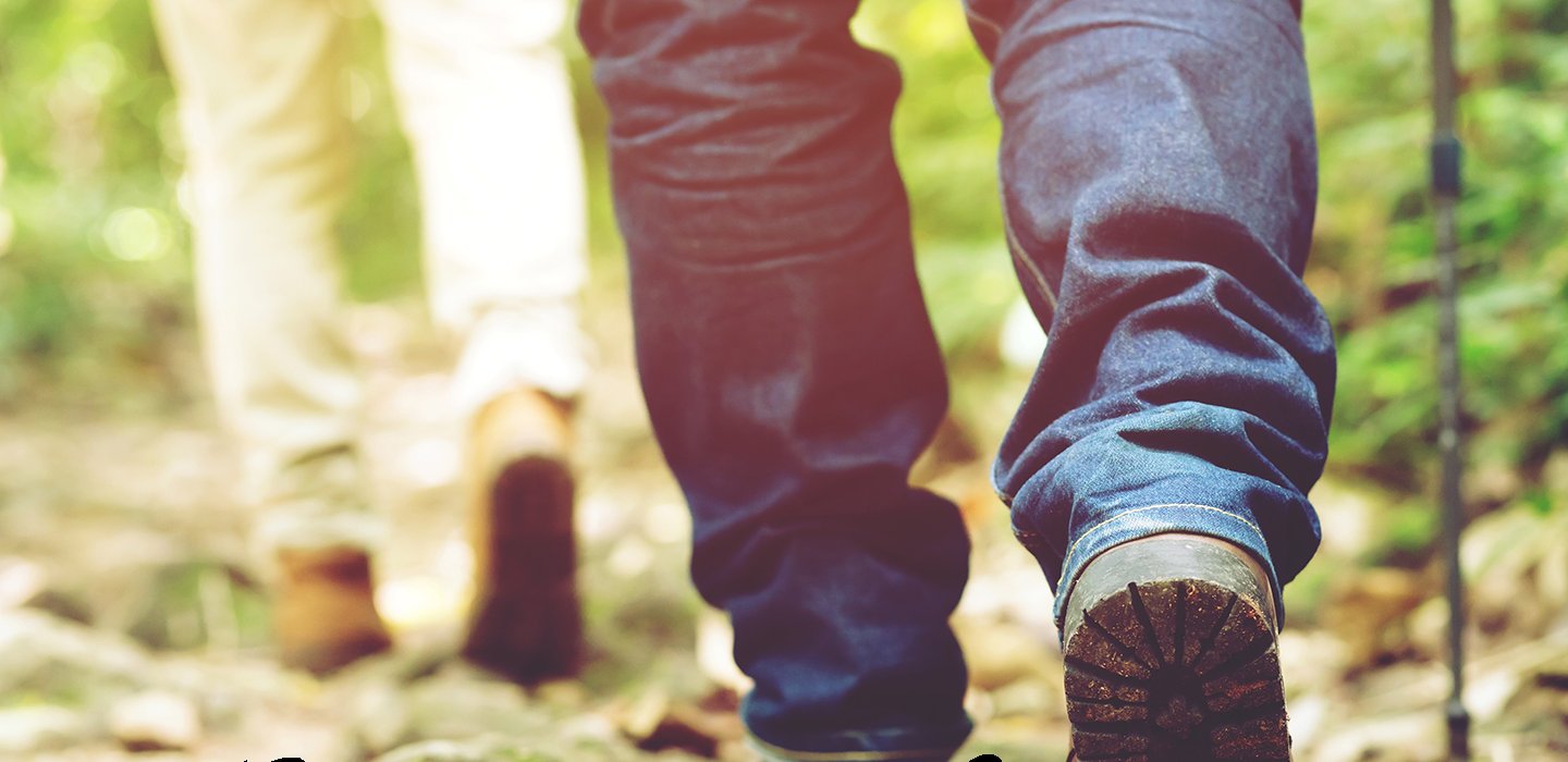 Twee mensen wandelen samen door een herfstig bos